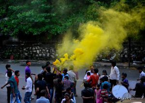 Coloured powder is thrown in the air during a procession
