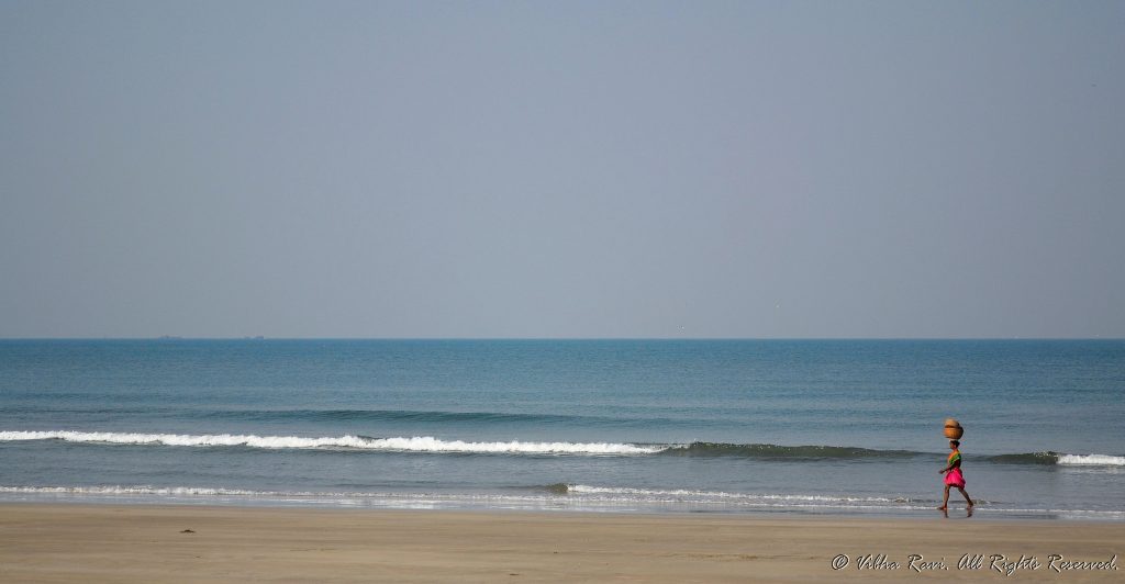 A fisherwoman walks on Tarkarli beach