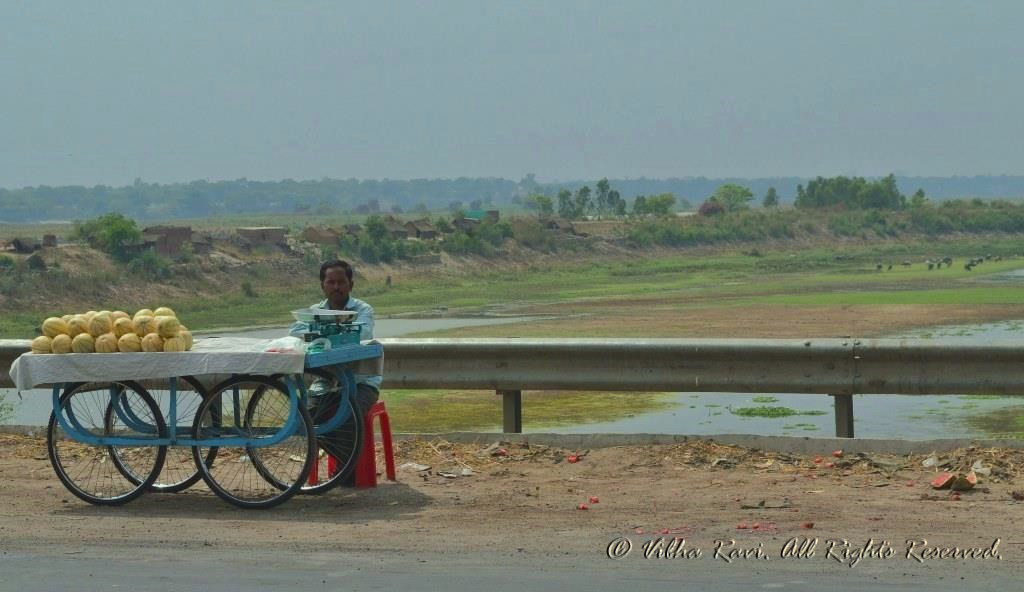 Fruit vendor on highway with Ganges in background