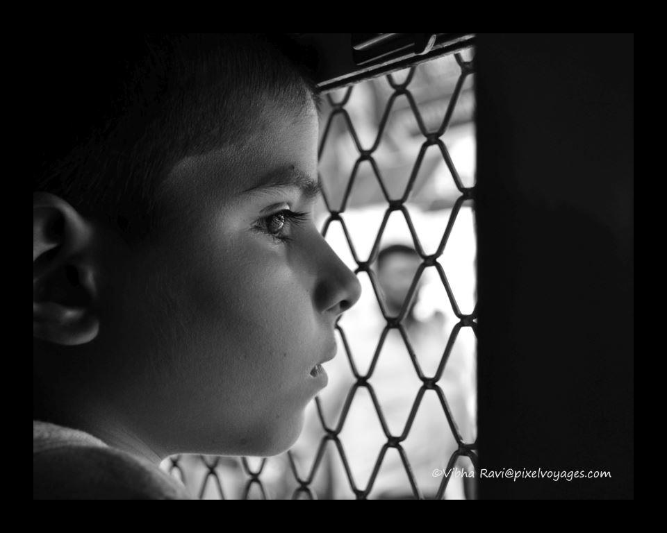 Child in Mumbai suburban train looks out a window